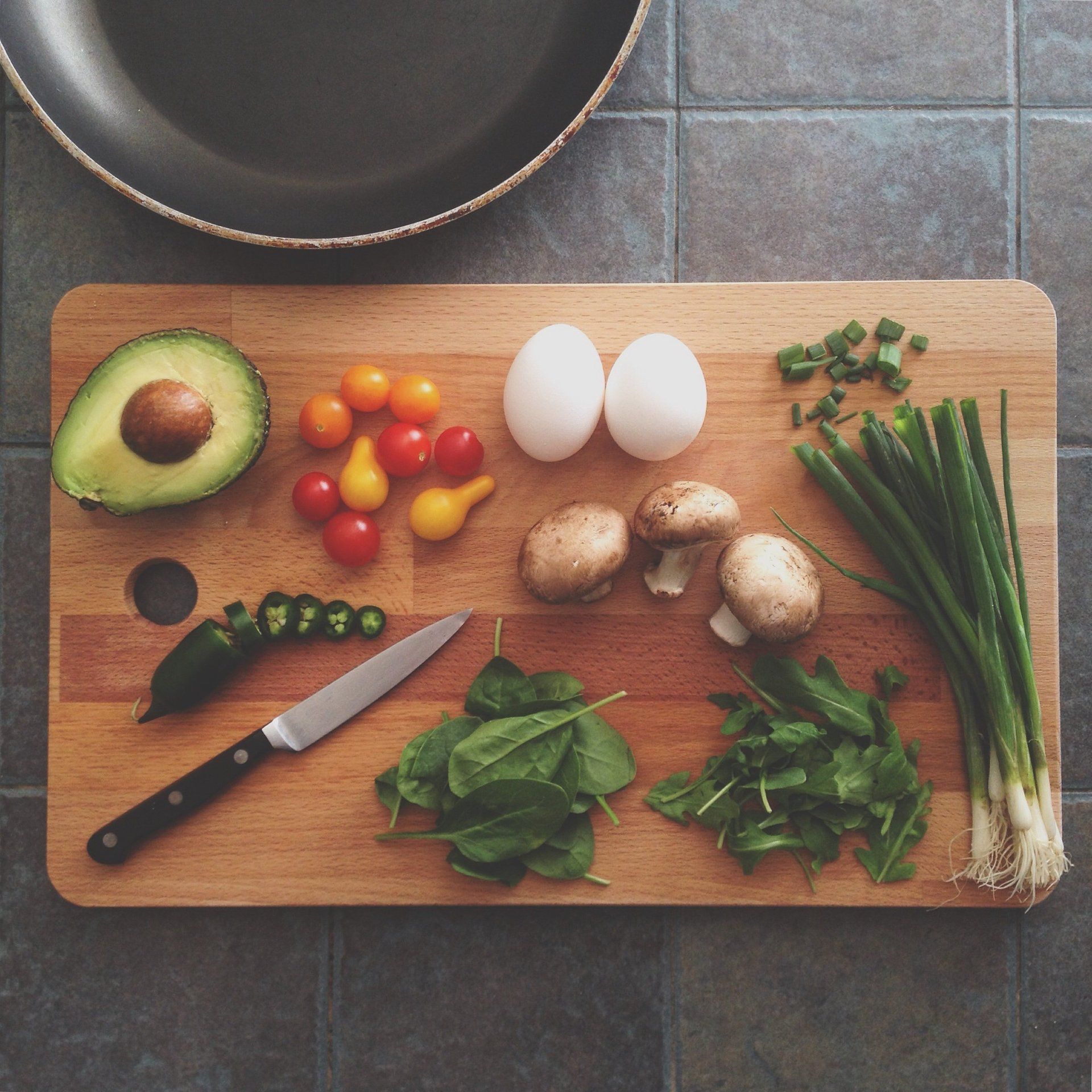 Fresh fruits, vegetables, and whole foods arranged on a table representing nutritional wellness